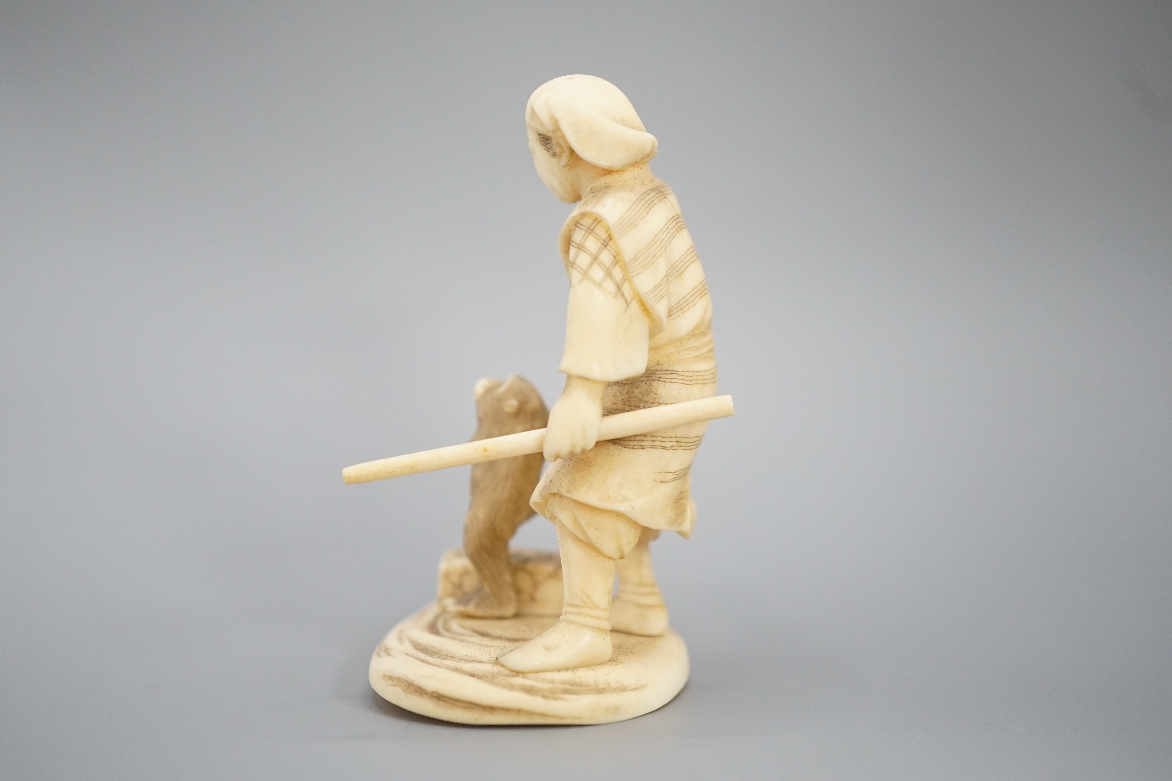 A Japanese ivory okimono of a monkey trainer, signed, Meiji period, 7.7 cm